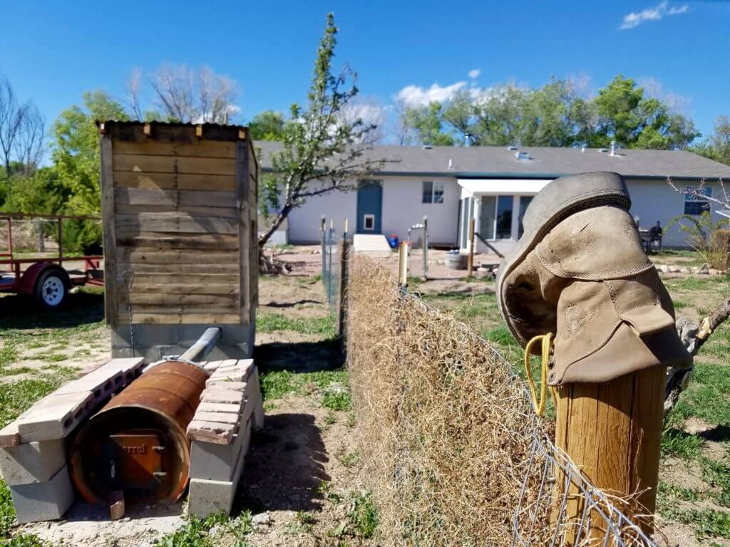 The Wheelers' handmade smokehouse on the left and farmhouse on the right.